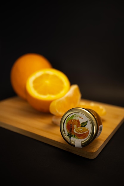 Una naranja entera media naranja rodajas de naranja y mermelada de naranja