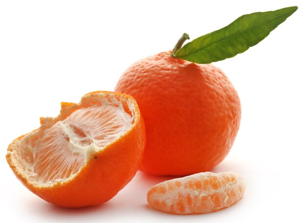 Naranja fresca con hoja verde sobre fondo blanco.