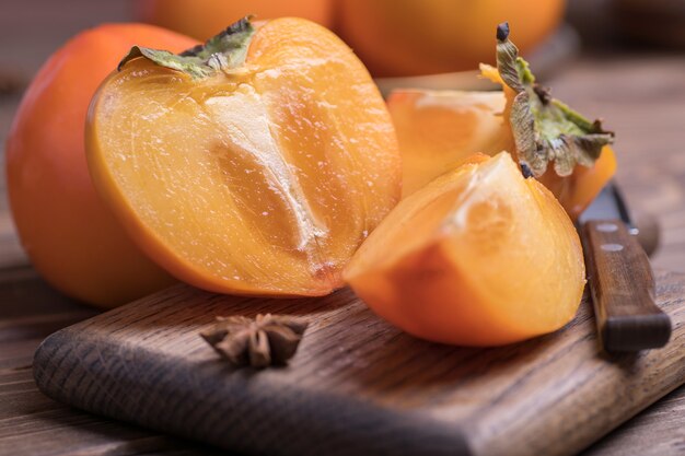 Naranja fresca madura, debajo de los caquis cortados en rodajas