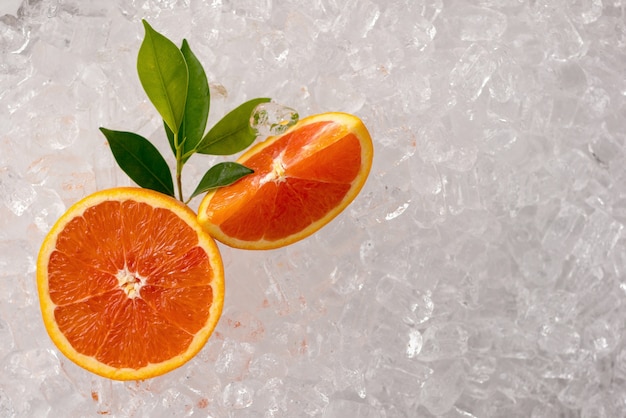 Naranja fresca y naranja en rodajas en el fondo del tubo de hielo