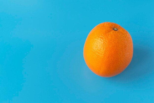 Naranja jugosa madura sobre un fondo azul Cítricos Vitaminas y alimentos para vegetarianos