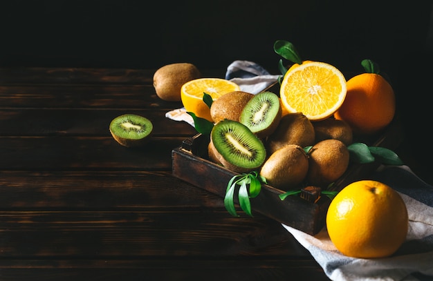 Naranja y kiwi en una mesa de madera