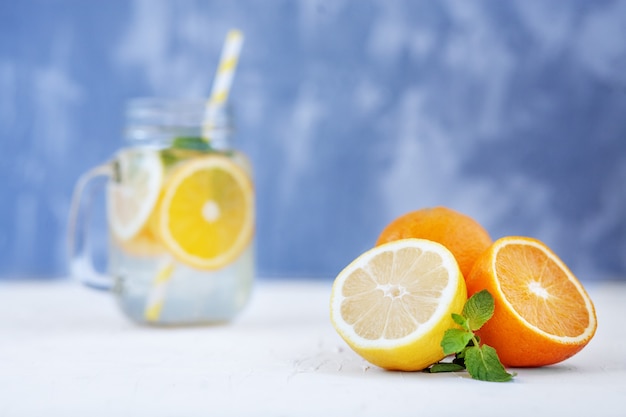 Naranja, limón y menta están sobre la mesa. Cóctel de frutas.