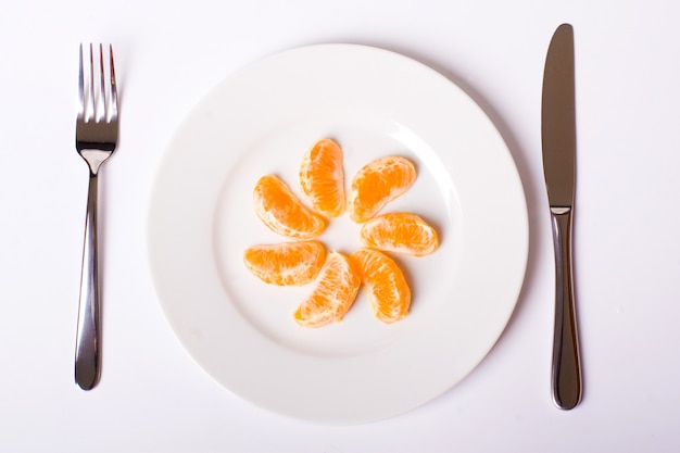 Naranja mandarina en plato blanco