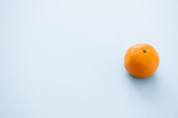 Naranja mandarina sobre un fondo azul.