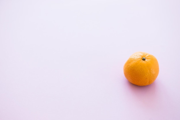 Naranja mandarina sobre un fondo rosa
