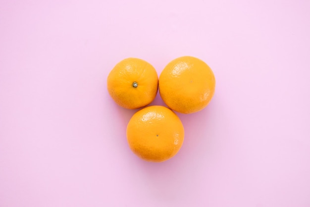 Naranja mandarina sobre un fondo rosa