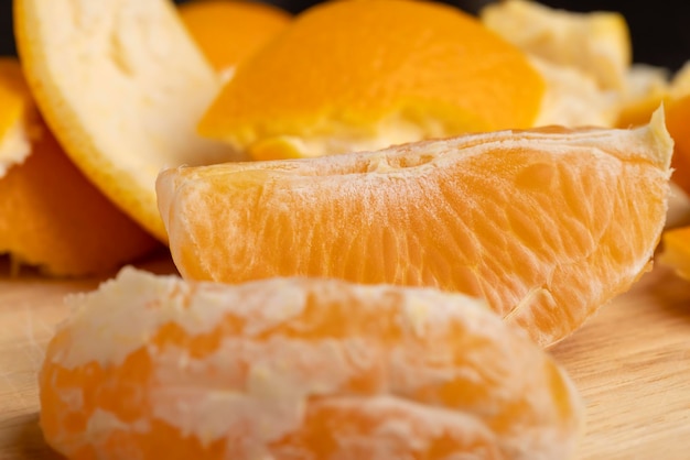 Naranja pelada dividida en rodajas sobre una tabla pelando una naranja madura y jugosa