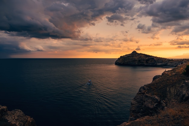 Naranja puesta de sol en el mar con montañas