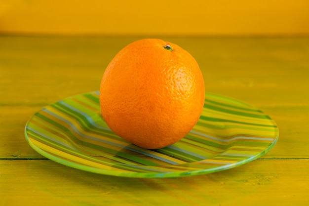 Foto naranja sobre la mesa de madera amarilla.