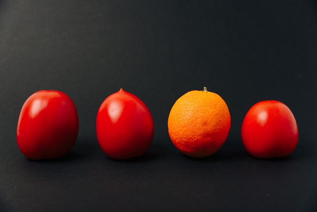 Naranja y tomates en una fila