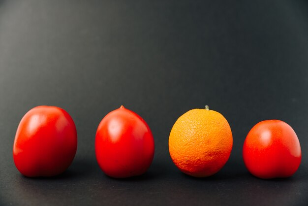 Naranja y tomates en una fila