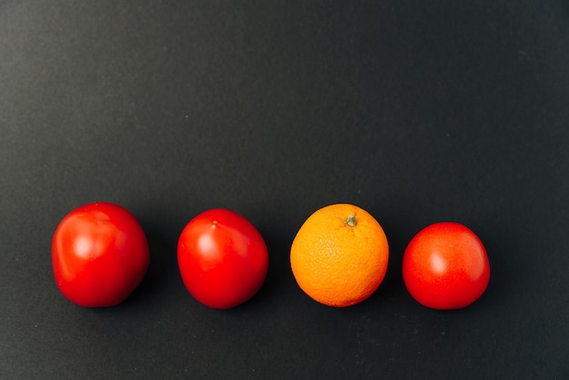 Naranja y tomates en una fila