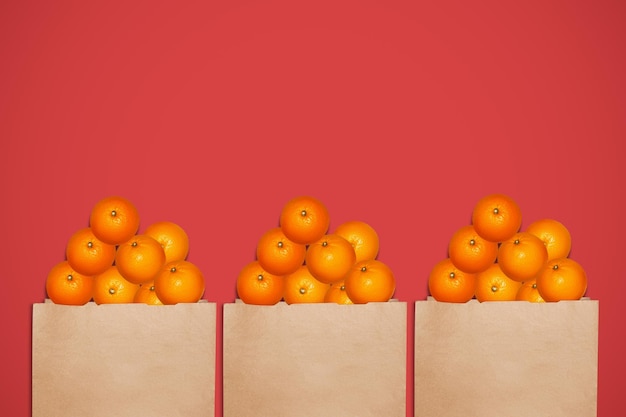 naranjas en una bolsa de papel sobre un fondo rojo