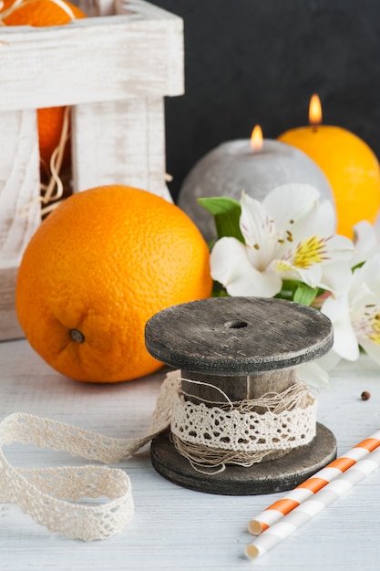 Naranjas en caja de madera, velas encendidas