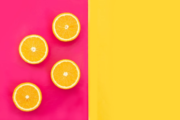 Naranjas cortadas por la mitad fruta sobre fondo rosa con fondo amarillo para textos