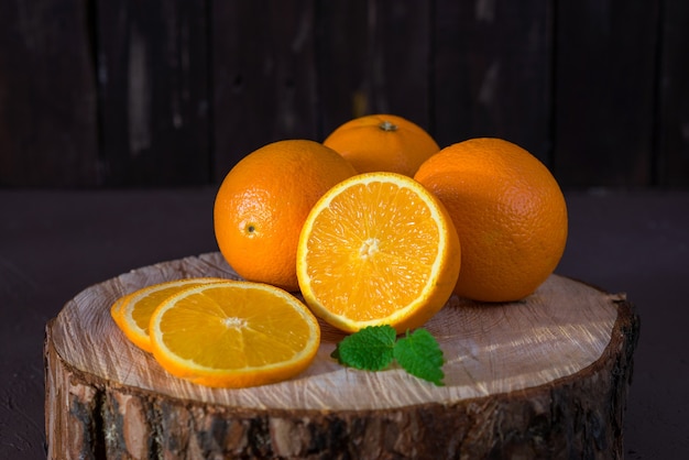 Naranjas enteras y rodajas sobre fondo de madera