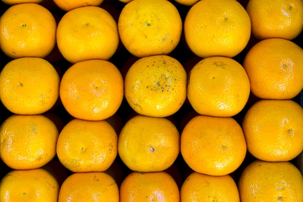 Foto naranjas en el fondo del mercado de frutas cosecha de cítricos frescos y jugosos en el mostrador del supermercado