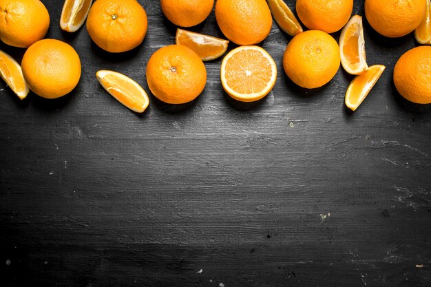 Naranjas frescas con hojas. En la pizarra negra.