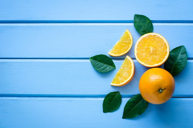 Naranjas frescas y jugo en la madera azul