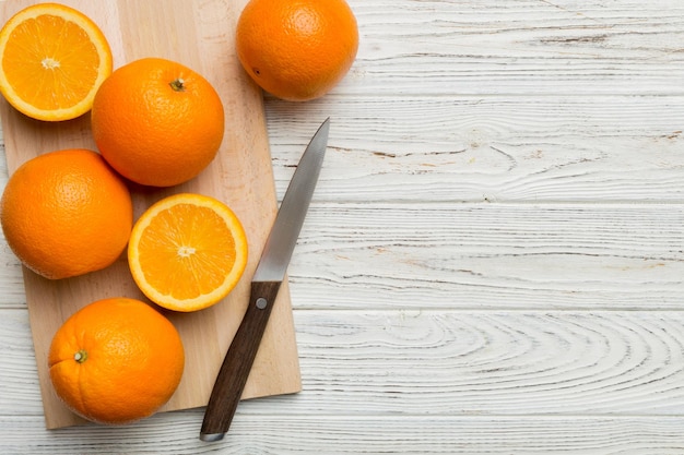 Foto naranjas frescas maduras en la tabla de cortar en la mesa vista superior