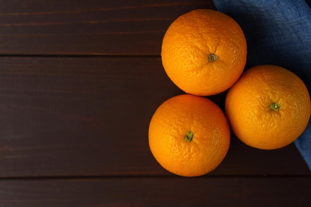 Naranjas fruta cerca de denim textil en tablero oscuro Naranja jugosa fruta cítricos concepto mínimo