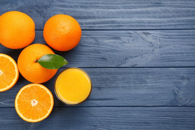 Naranjas con jugo en mesa de madera