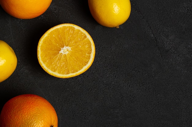 Naranjas y limones sobre fondo oscuro de hormigón