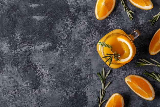 Naranjas maduras frescas y jugo en la mesa de piedra.