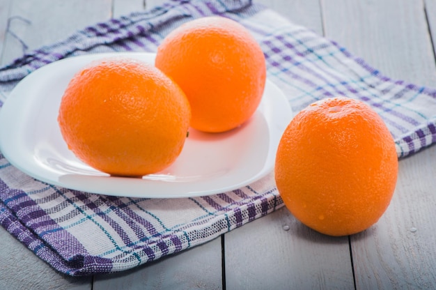 Naranjas maduras frescas sobre una mesa de luz natural