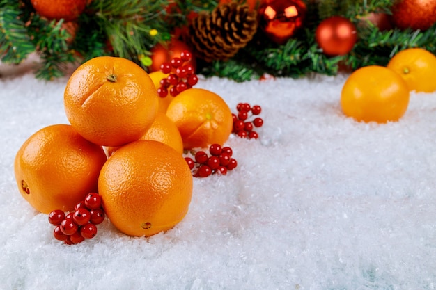 Naranjas orgánicas en bandeja navideña con adorno. Concepto de comida sana.