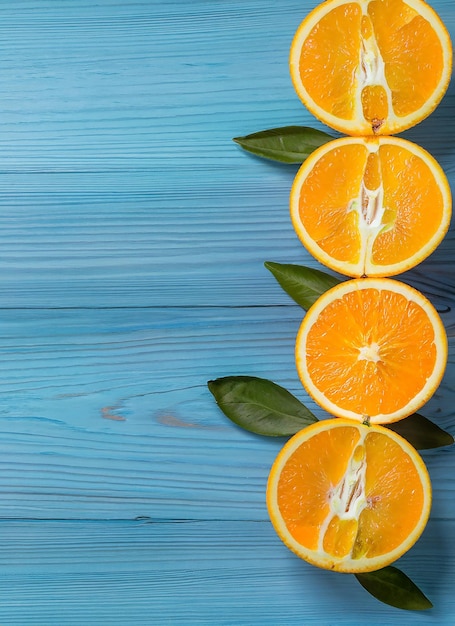 Naranjas orgánicas frescas dividen las frutas en dos sobre un fondo de madera azul con espacio de copia