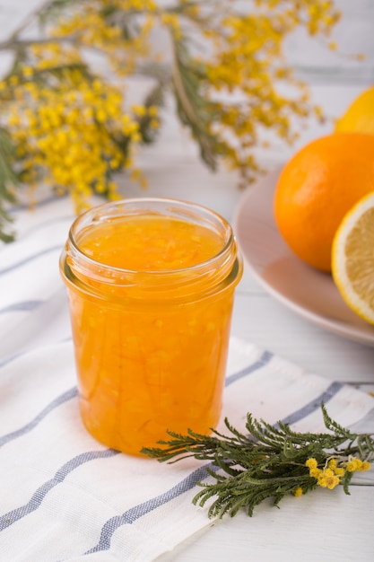 Naranjas en rodajas y mermelada de naranja en un frasco de vidrio