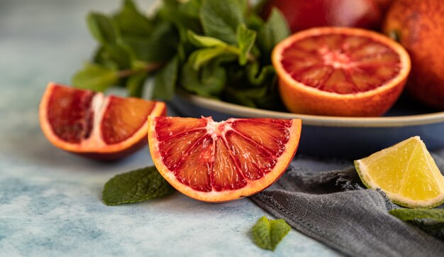 Naranjas rojas de Sicilia con limas y menta Cítricos enteros y en rodajas