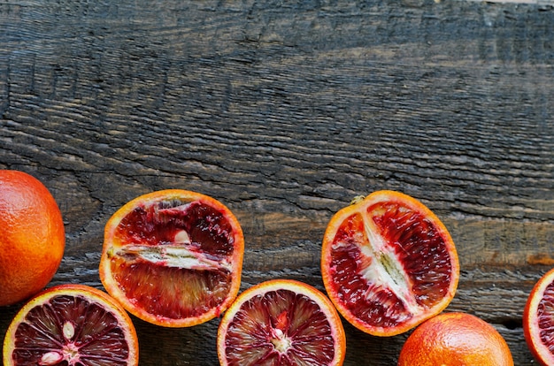 Naranjas de sangre sicilianas cortadas y cortadas en madera natural