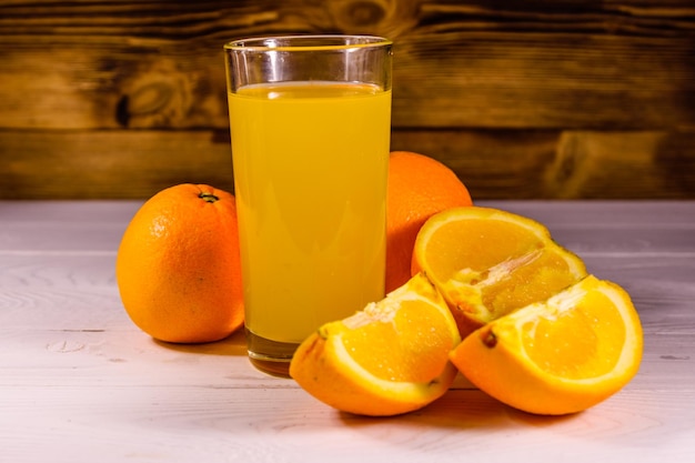 Naranjas y vasos con jugo de naranja en una mesa de madera