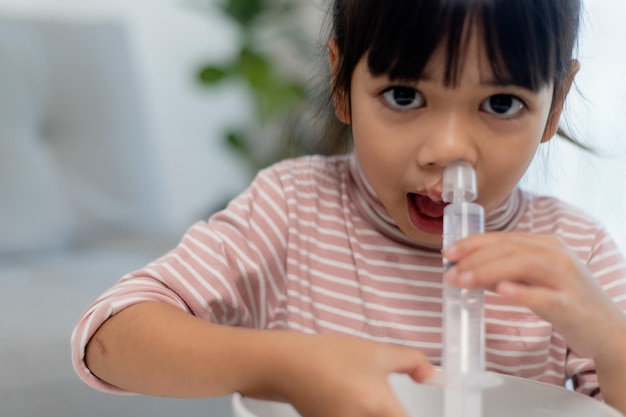 Nariz de lavagem nasal salina menina asiática em casa