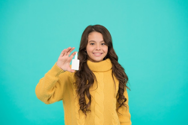 Nariz escorrendo e outros sintomas de resfriado. Alergia sazonal. As crianças usam medicamentos eficazes. Menina segura gotas nasais. Conceito de alergia. Tratamento em casa. Garrafa de plástico de gotas nasais. Spray nasal eficaz.