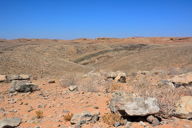 Nas colinas do deserto espalharam pedras de tamanhos diferentes nas encostas e no céu azul