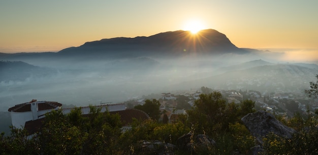 Nascer do sol com nevoeiro na montanha