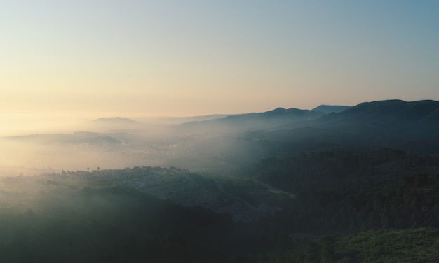 Nascer do sol com nevoeiro na montanha