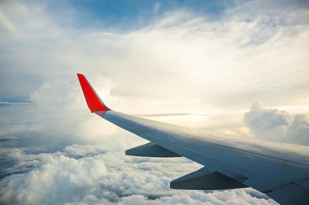 Nascer do sol da manhã com a asa de um avião voando sobre o oceano A vista da janela de um avião Foto aplicada à imagem de operadoras de turismo para adicionar mensagem de texto ou site de quadro