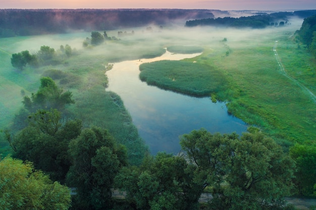 Nascer do sol da manhã enevoada sobre a paisagem rural do lago no verão Vista aérea