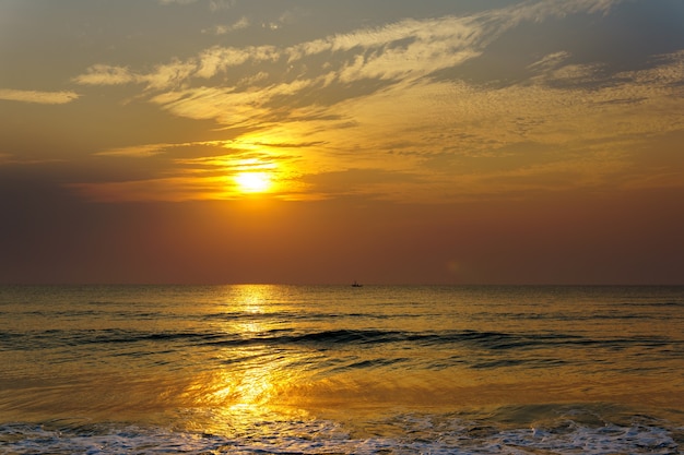 Nascer do sol de manhã cedo sobre o mar e o pequeno barco de pesca