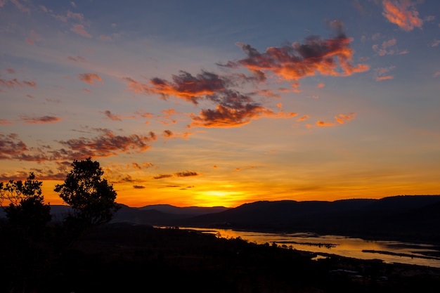 Nascer do sol dourado sobre o rio kong e montanha