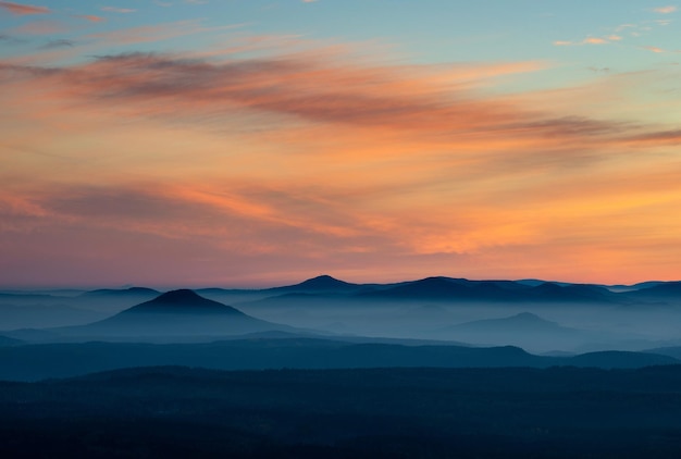 Nascer do sol dramático sobre belos picos de montanha Decinsky Sneznik República Checa