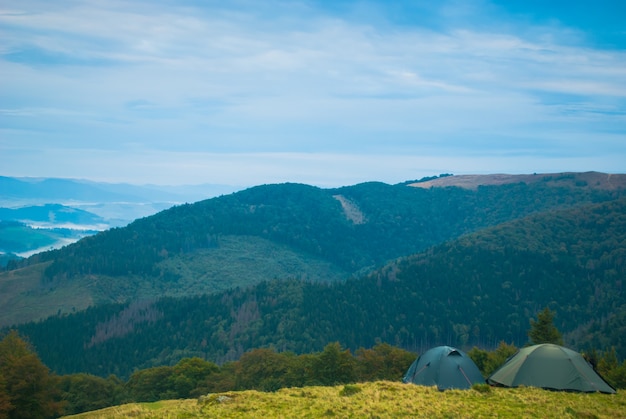 Nascer do sol na manhã nublada e tendas nas montanhas dos Cárpatos no verão