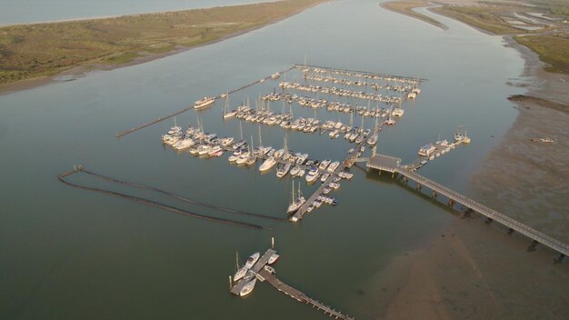 Foto nascer do sol na marina barcos no estuário com o mar ao fundo vista aérea