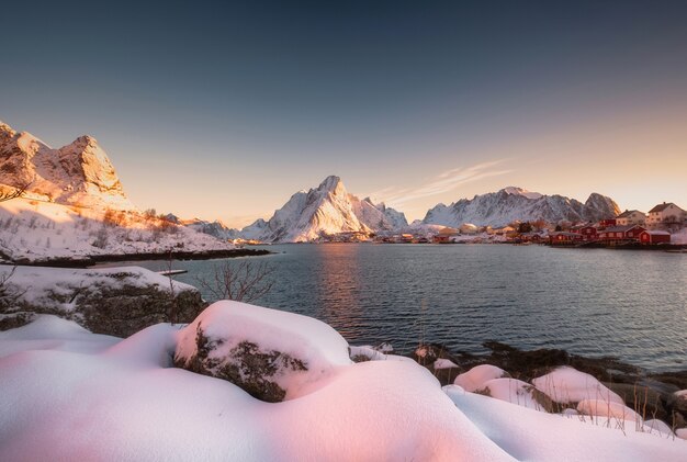 Nascer do sol na neve na vila reine no inverno no litoral, nas ilhas lofoten, na noruega