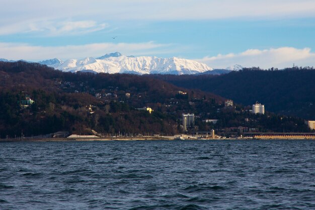 Nascer do sol na névoa rosa do mar do sol nascente sobre a cidade do mar e as montanhas no horizonte sochi ...